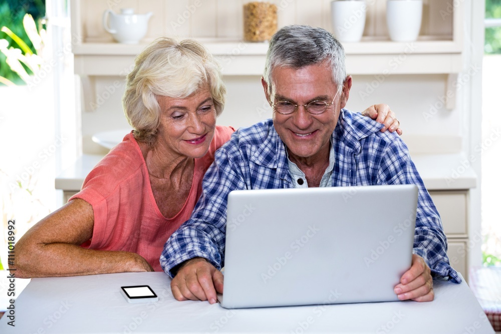 Senior couple using laptop at home Senior couple using laptop at home