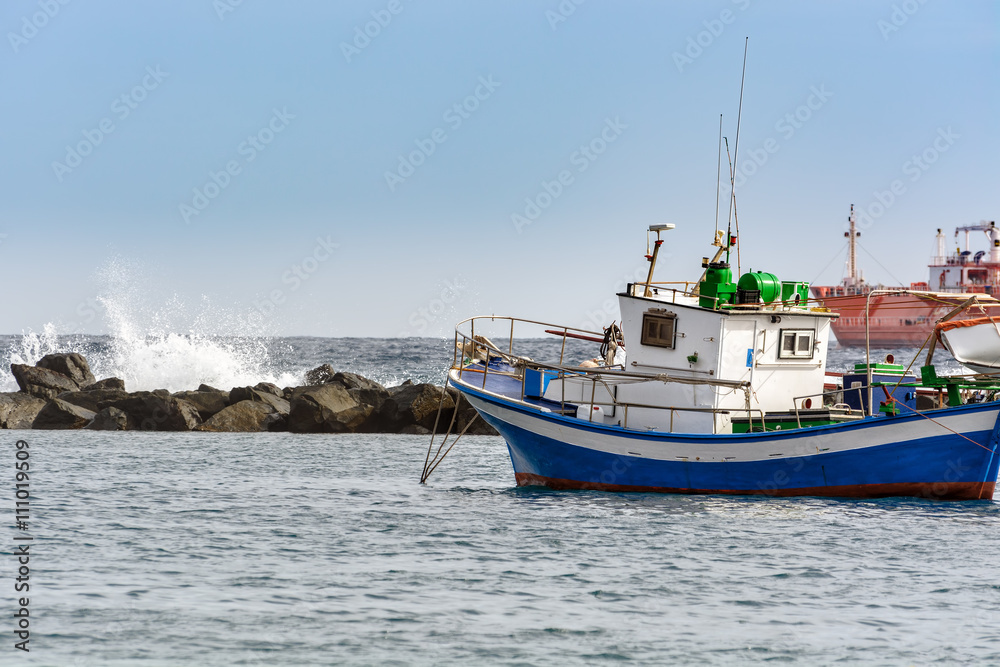 Fototapeta premium Small fishing boat at an ocean port of Santa Cruz town on Tenerife island