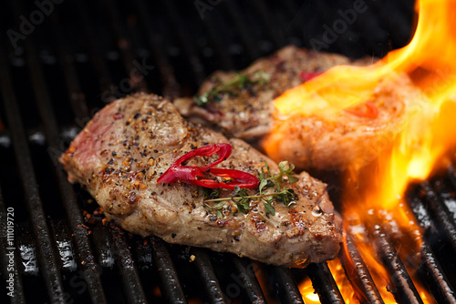 pork steak on bbq grill with flame
