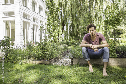 Young man sitting in garden photo
