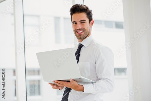 Businessman using laptop and taking notes