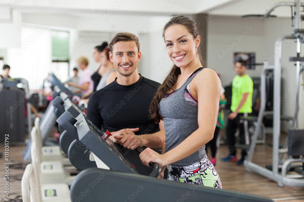 Happy coach assisting young woman in a gym Happy coach assisting young woman in a gym
