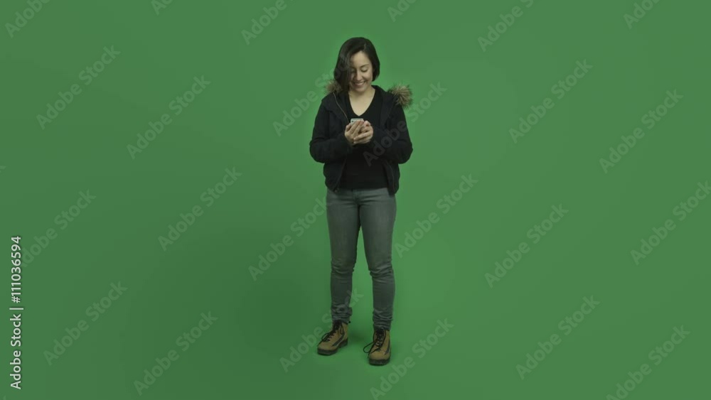 caucasian girl with winter jacket isolated on green screen smiling with cell phone caucasian girl with winter jacket isolated on green screen smiling with cell phone