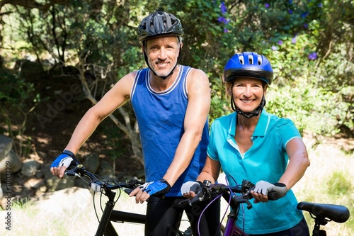 Mature couple posing with their bike