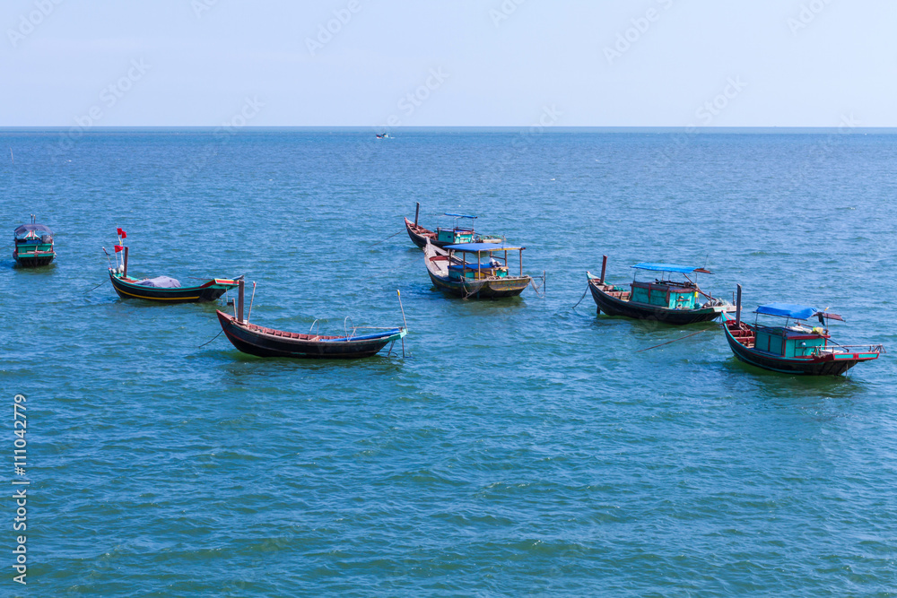  Fishing village with wooden boat berth at seashore and coracle float on water in Hai Hau, Viet Nam