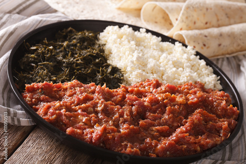Ethiopian cuisine: kitfo with herbs and cheese and injera. Horizontal
 photo