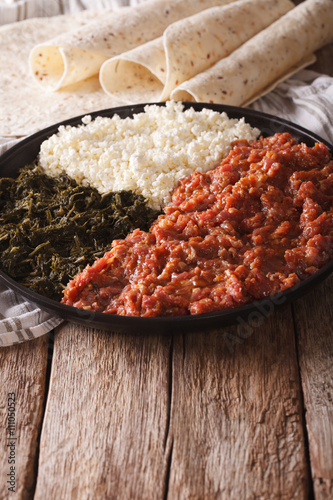 Ethiopian cuisine: kitfo with herbs and cheese. Vertical
 photo