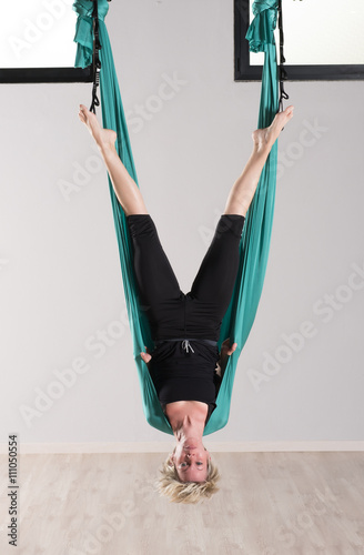 Upside down woman doing aerial yoga head stands