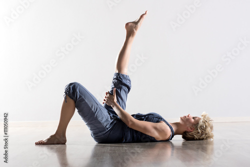 Woman on back stretching hamstring muscles photo
