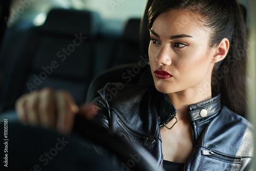 Portrait of young attractive unsmiling woman driving