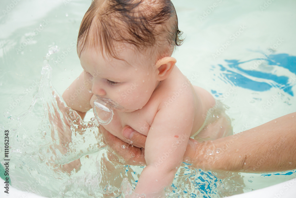 Little newborn baby bathe and swim