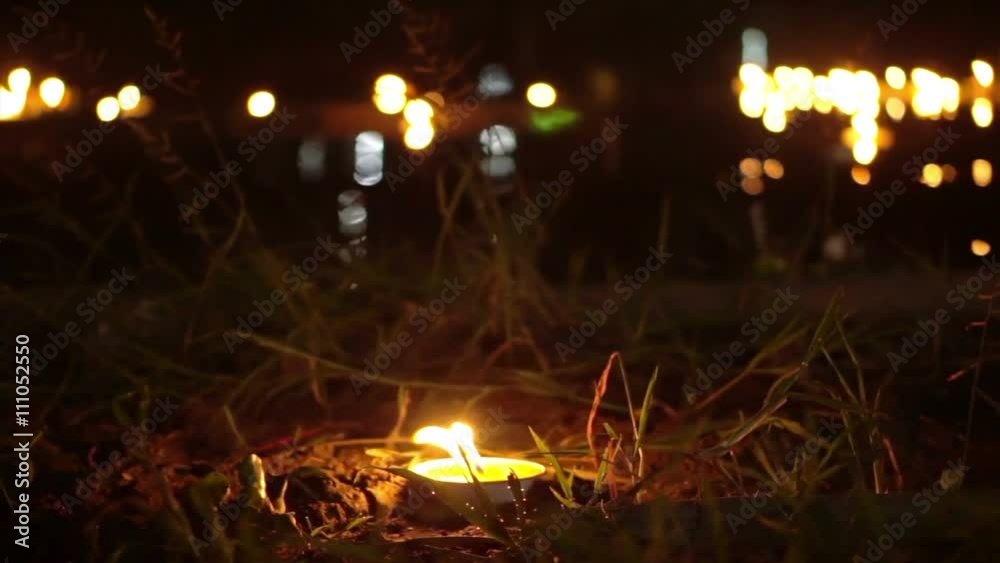 Candle lit at night to pay respect to river goddess at Loi Krathong festival Thailand. 