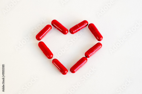 Red heart pill .Represents medication for heart disease photo