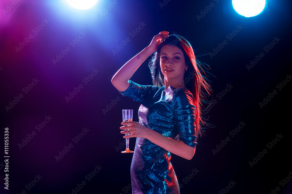 The beautiful girl dancing at the party drinking champagne