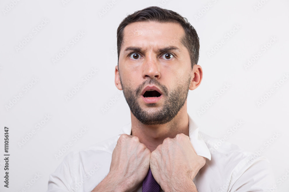 Exhausted young businessman loosening tie