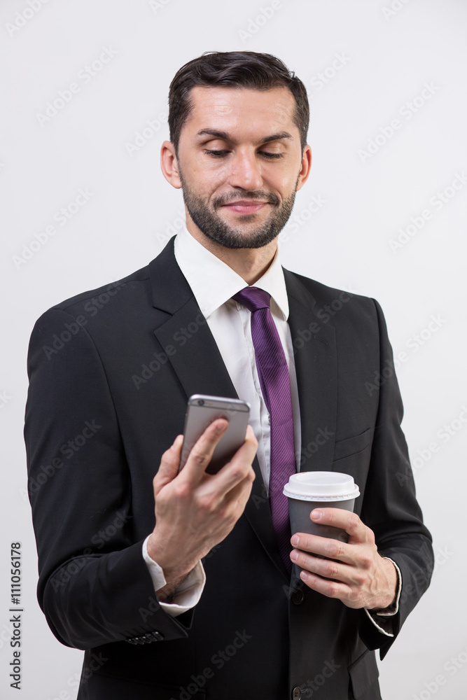 Young business man with a phone and coffee