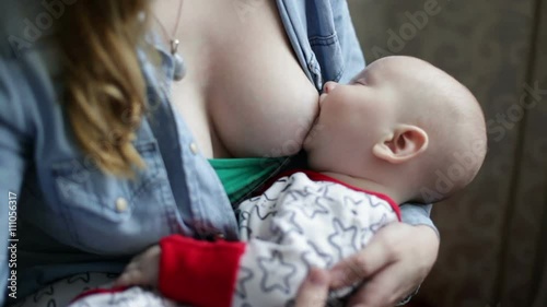 Close-up breast-feeding , baby is sleeping and sucking the breast