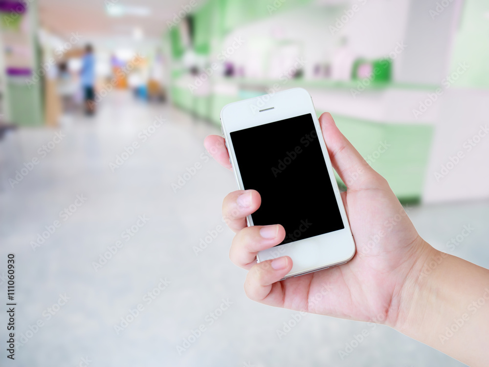 female using smartphone with blur hospital background