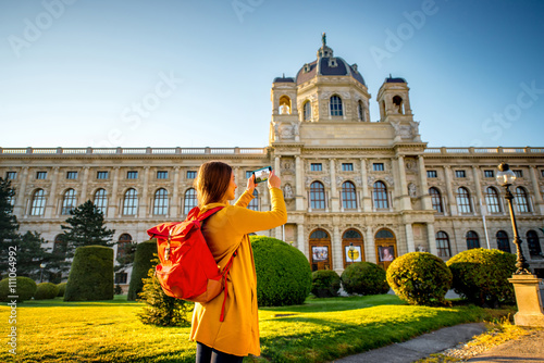 Young female tourist photographing with smart phone museum of Art History in Vienna. photo