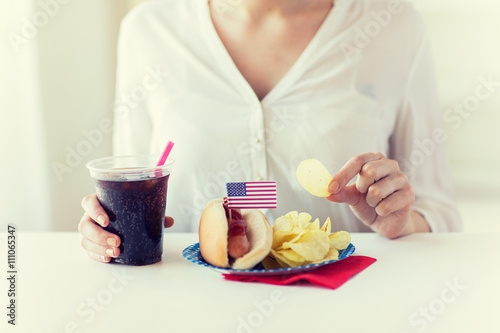 close up of woman eating chips  hot dog and cola