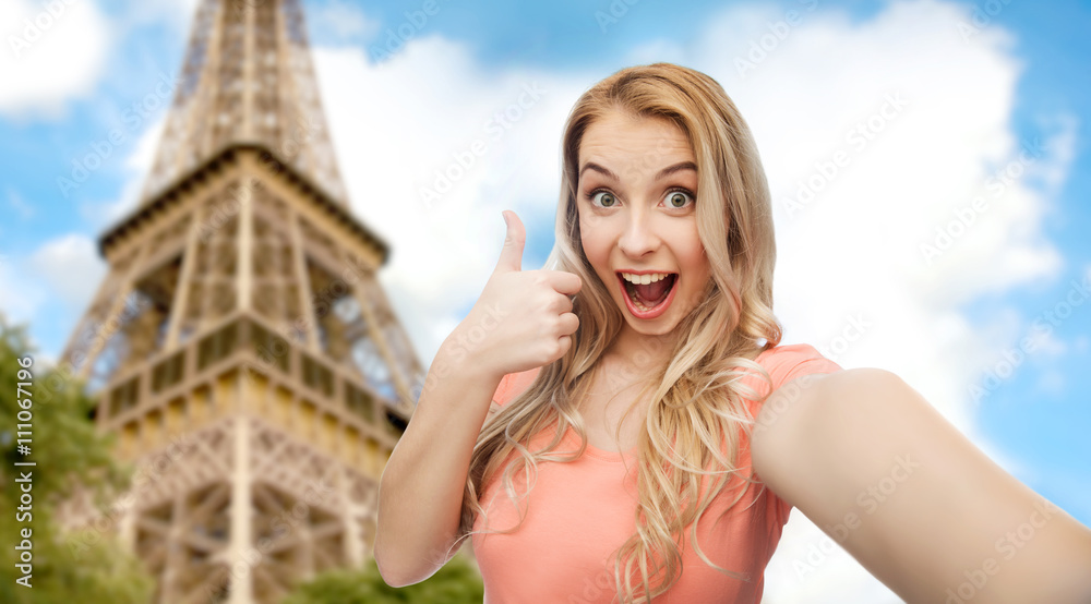 happy woman taking selfie and showing thumbs up