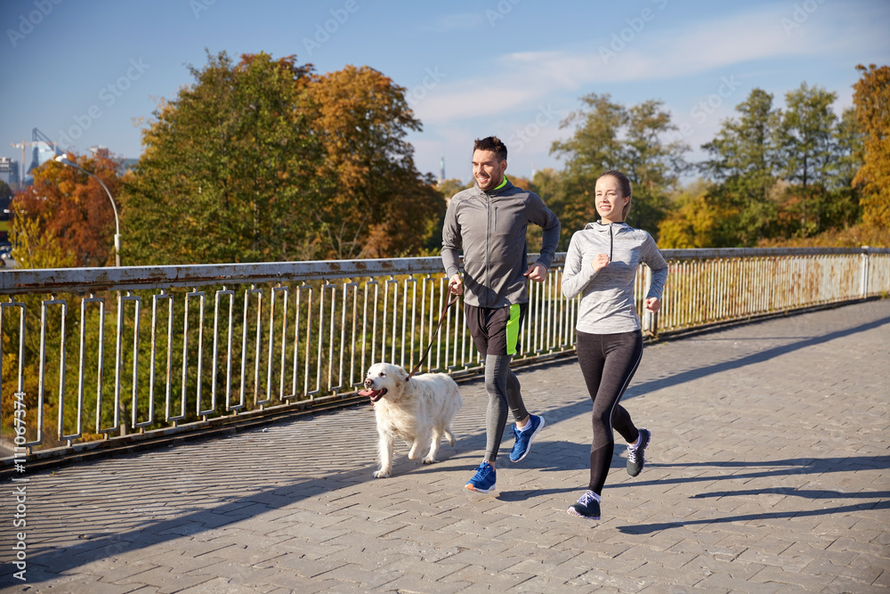 happy couple with dog running outdoors happy couple with dog running outdoors