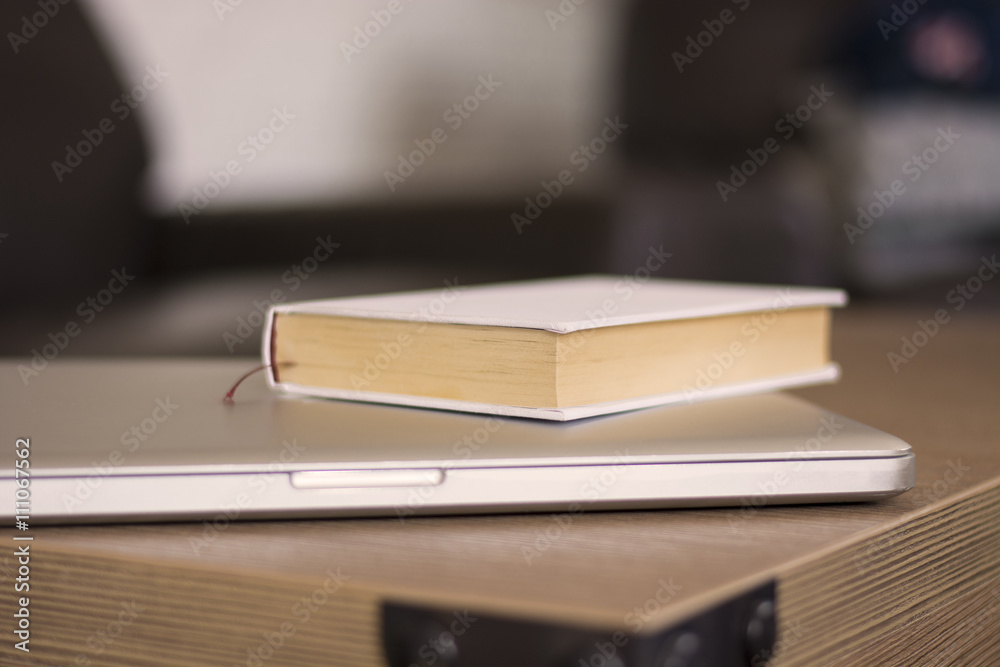 Book and laptop on a wood table Book and laptop on a wood table
