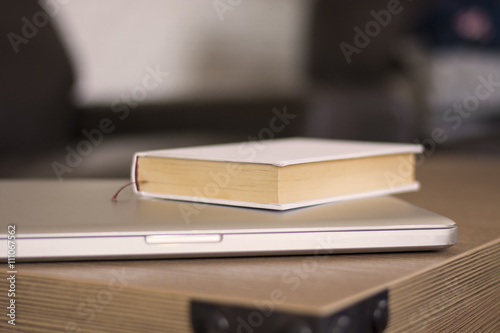 Book and laptop on a wood table