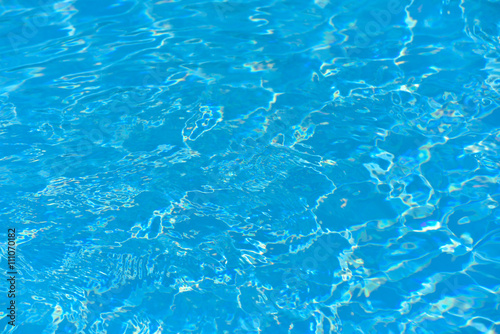 Blue water in swimming pool and water surface with sun reflection