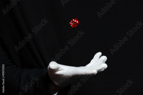 Hand of magician in white glove showing tricks with dice