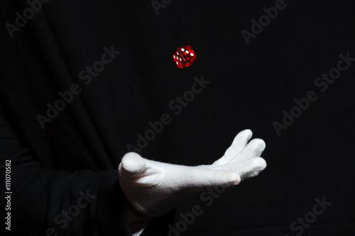 Hand of magician in white glove showing tricks with dice