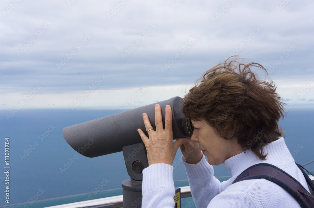 Woman looking through tourist telescope
