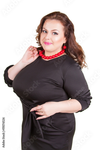 Obraz na plátně Pretty confident buxom girl in a black dress standing isolated on white backgrou