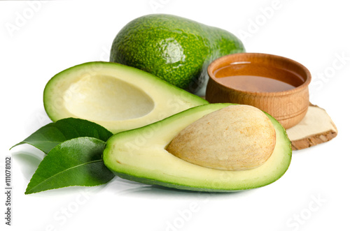 fresh avocado with avocado oil in the wooden bowl isolated on wh