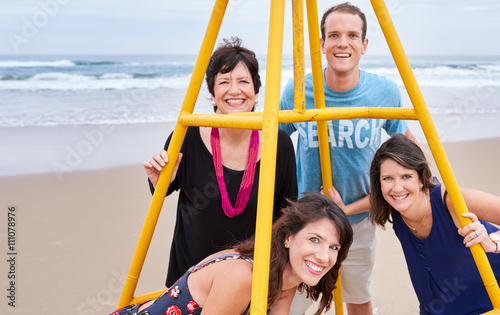 Family posing together around a structure on the beach