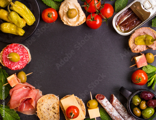 Spanish tapas on a black stone background