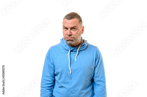 Grumpy man in blue sweater near white wall © michaelheim