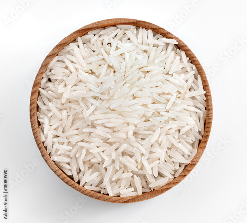 White rice in wooden bowl on white background. Close up, top view, high resolution product.