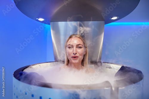 Woman in a whole body cryotherapy cabin