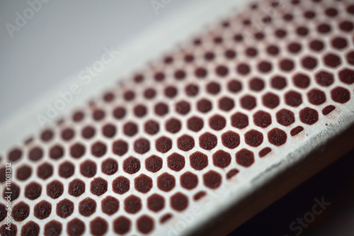 Box of safety matches with its black striking surface with the honeycomb shapes on the narrower side 
