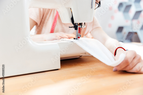 Seamstress sews clothes using white fabric