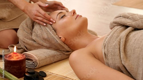Woman getting facial massage in spa