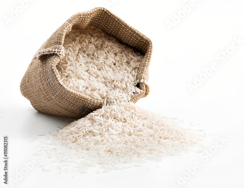 Sack with scattered rice on white background. Close up, high resolution product.