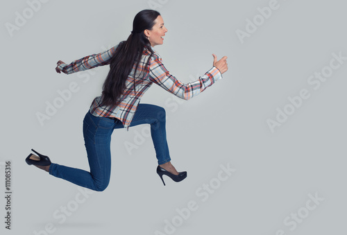 Full length portrait of woman running sideways