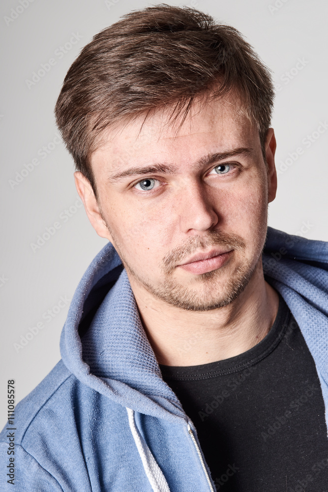 Fototapeta premium Serious young man with light beard in blue hoodie