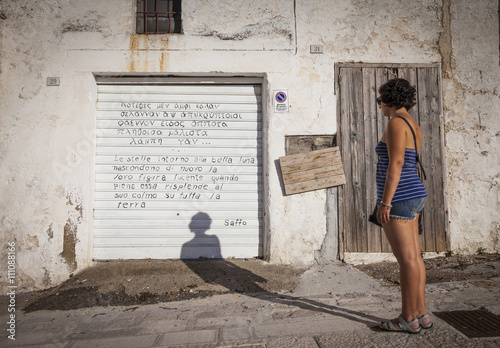 Girl reads poem written on rolling shutter.