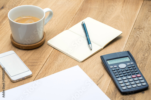 Wooden workspace with office supplies and coffee