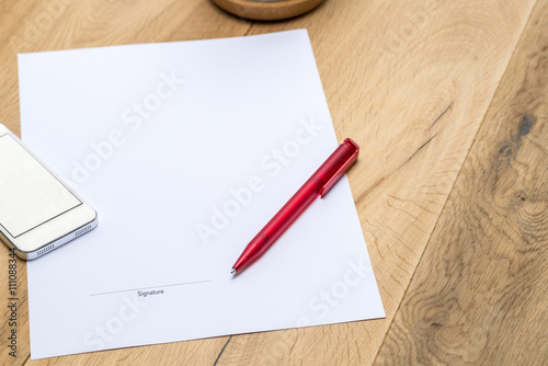 Paper with signature and red pen on desk