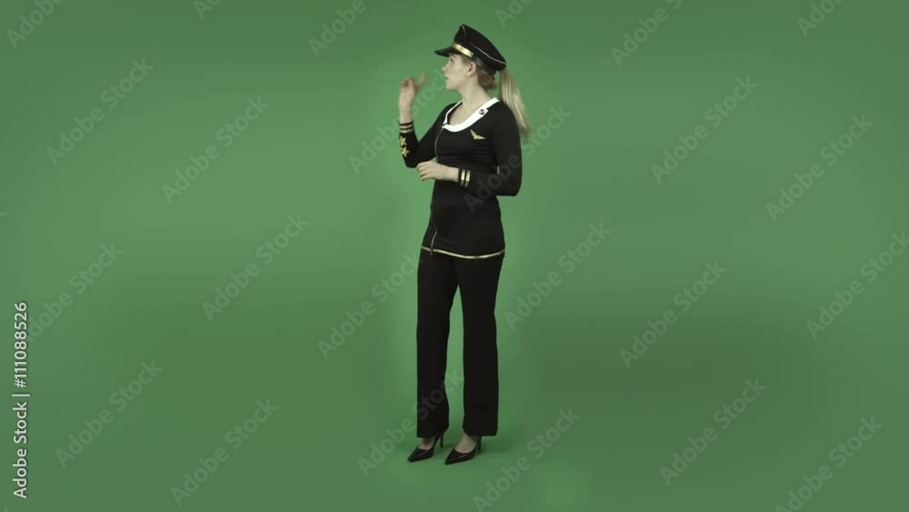 attractive caucasian air hostess isolated on green talking and pointing attractive caucasian air hostess isolated on green talking and pointing