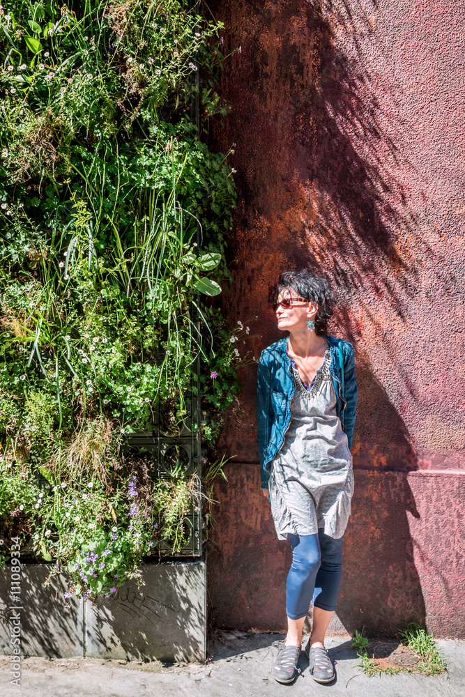 Obraz premium Femme devant le mur végétal Rue de l'Annonciade à Lyon